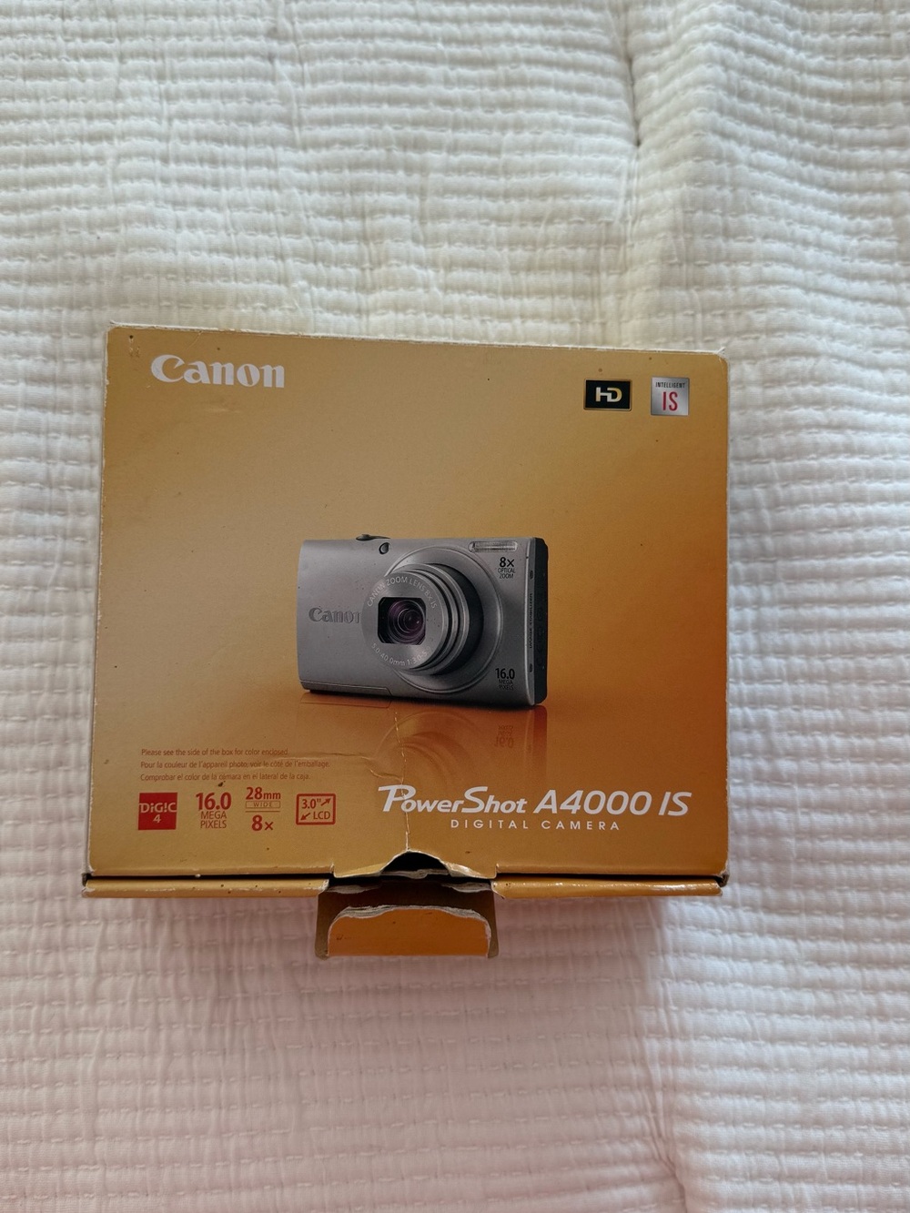 Canon PowerShot A4000 IS Digital Camera - Gold Box with Silver Camera Image